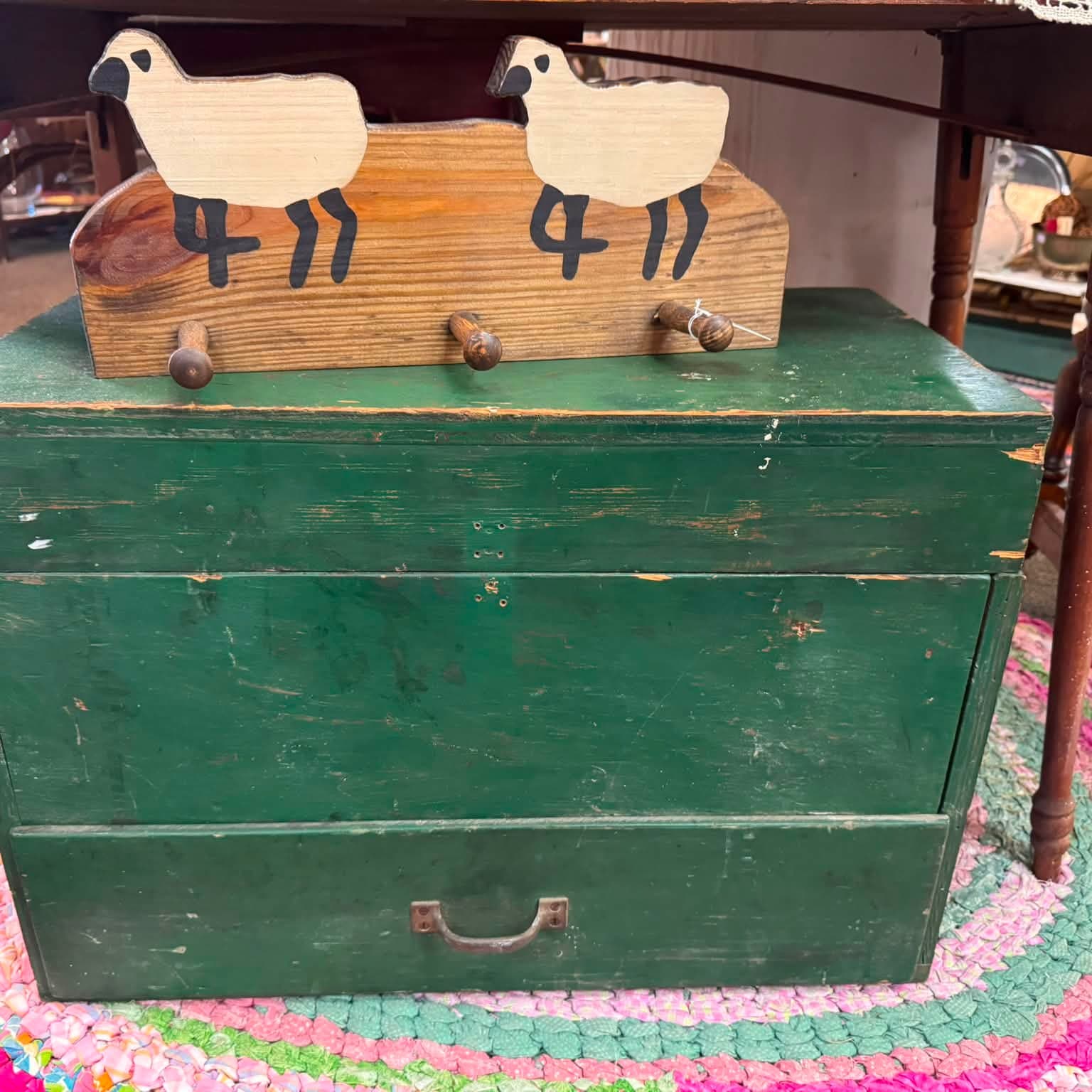 Green painted blanket chest topped with a folk-art sheep bench