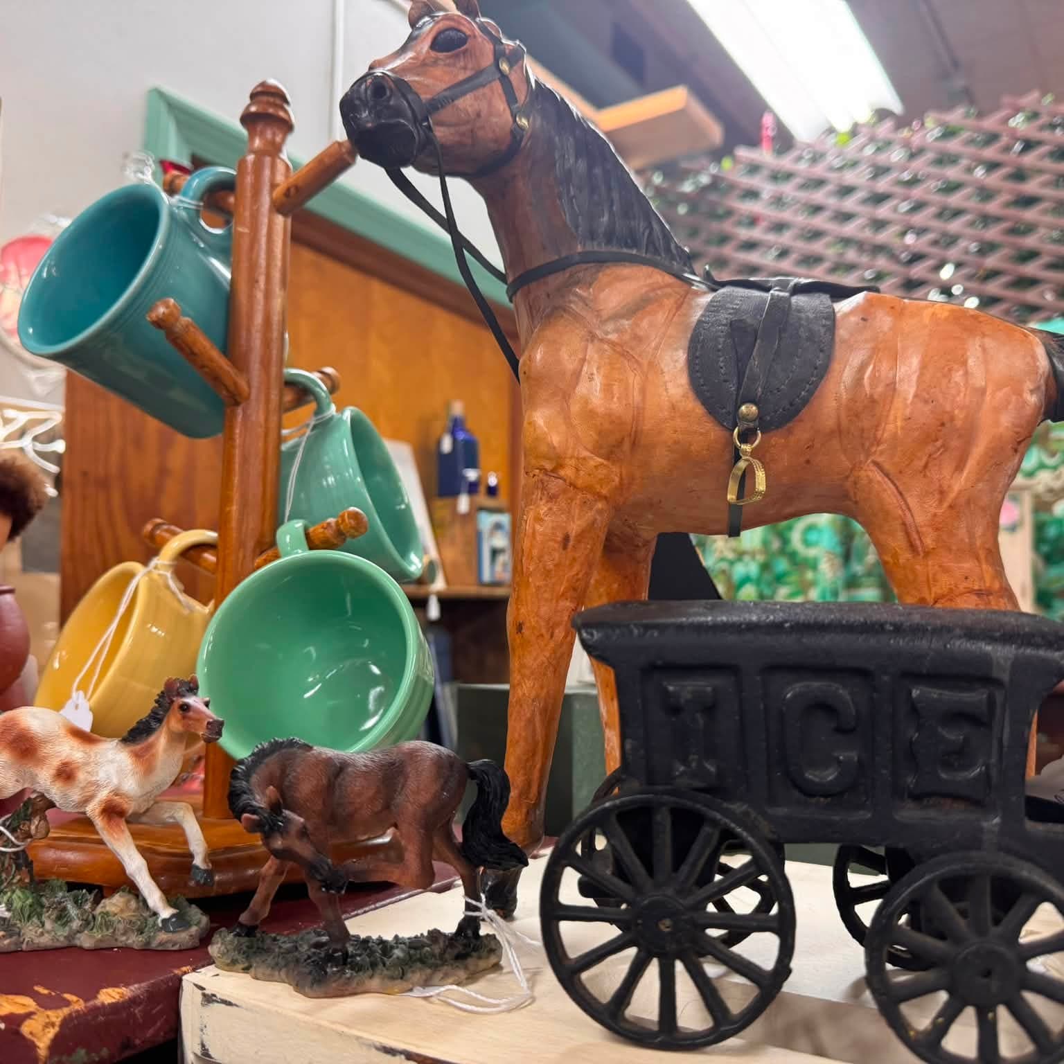 Carved wooden horse and cast-iron wagon on a shop table
