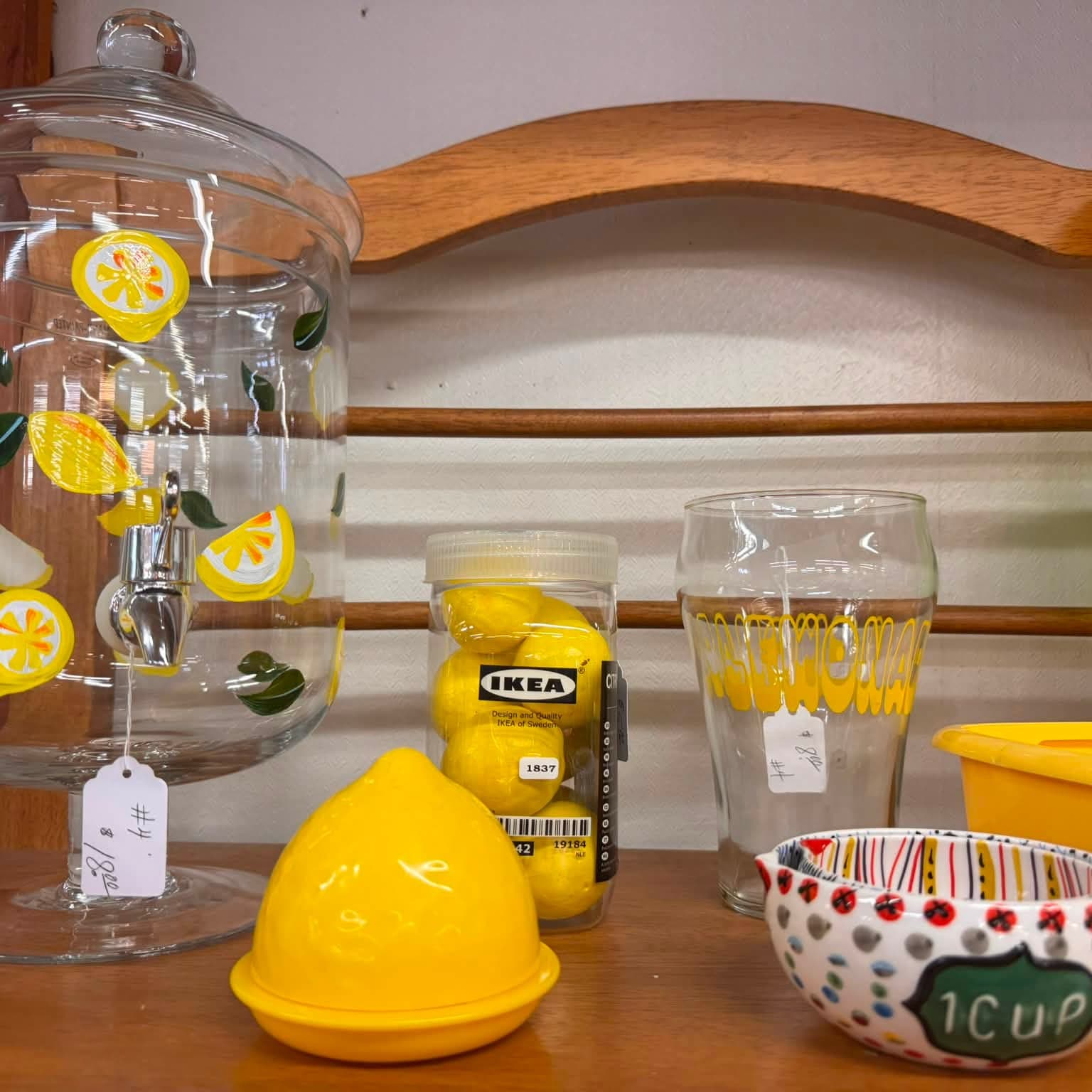 Yellow glassware, a covered apothecary jar and a polka-dot bowl on a hutch
